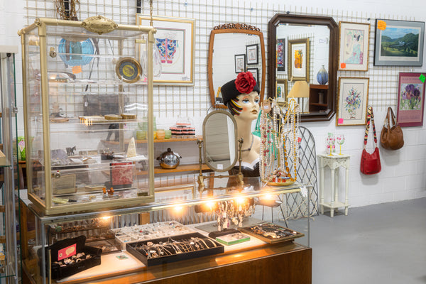 A vendor booth with a jewelry case and other items