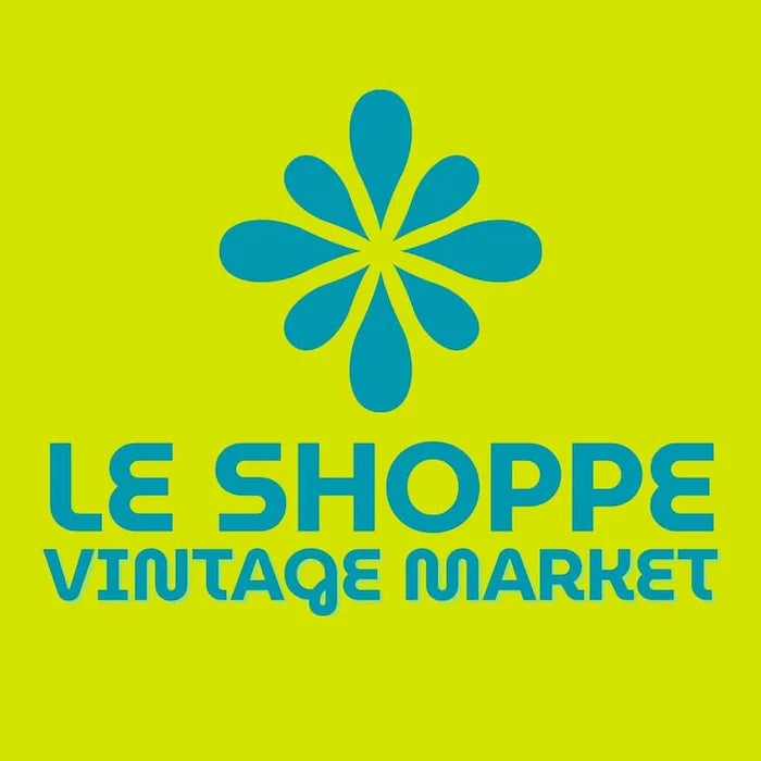 Le Shoppe Vintage Market logo with a blue flower design on a green background