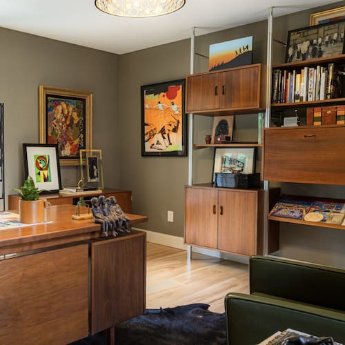 Living room with wooden furniture, bookshelf, and decorative items.